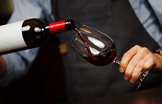 Red wine being poured into a crystal glass